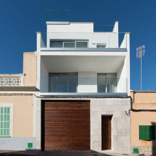 Ejemplo de fachada de casa blanca, minimalista, de tres plantas, con revestimiento de estuco y tejado plano