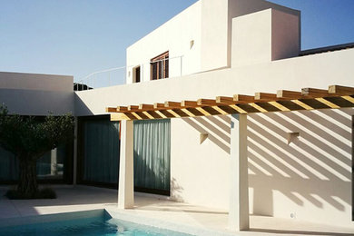 Ejemplo de fachada de casa blanca mediterránea grande de dos plantas con revestimiento de estuco, tejado plano y tejado de varios materiales