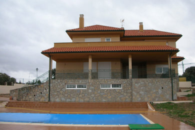 Ejemplo de fachada de casa beige campestre extra grande con revestimiento de ladrillo, tejado a cuatro aguas y tejado de teja de barro