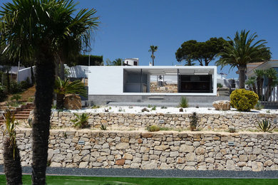 Diseño de fachada blanca mediterránea pequeña de una planta con tejado plano
