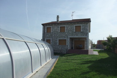 Foto de fachada gris rural de tamaño medio de dos plantas con revestimiento de piedra y tejado a dos aguas