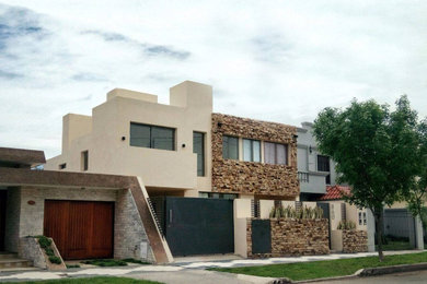 Ejemplo de fachada de casa pareada beige minimalista grande de dos plantas con revestimiento de piedra, tejado plano y tejado de varios materiales