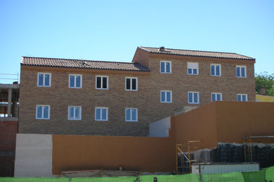 Diseño de fachada de piso marrón moderna extra grande con revestimiento de ladrillo, tejado a dos aguas y tejado de teja de barro