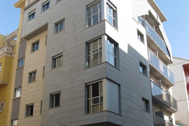 Foto de fachada gris minimalista grande de tres plantas con revestimiento de piedra y tejado plano