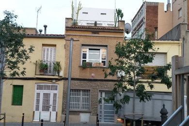 Design ideas for a beige traditional house exterior in Barcelona with three floors and a flat roof.