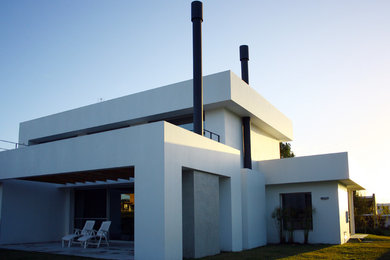 Diseño de fachada blanca moderna de dos plantas con revestimientos combinados y tejado plano
