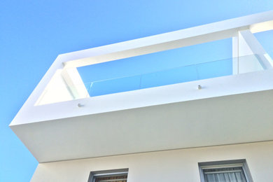 Foto de fachada de casa pareada blanca de tamaño medio de dos plantas con revestimientos combinados, tejado plano y tejado de varios materiales