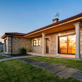 Foto de fachada de casa beige, mediterránea, de tamaño medio, de una planta, con revestimiento de piedra, tejado a cuatro aguas y tejado de teja de barro