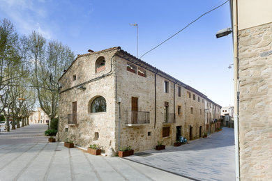 Идея дизайна: двухэтажный, бежевый дом среднего размера в средиземноморском стиле с облицовкой из камня и двускатной крышей
