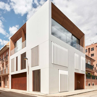 Diseño de fachada de casa pareada blanca, minimalista, grande, de tres plantas, con revestimientos combinados y tejado plano
