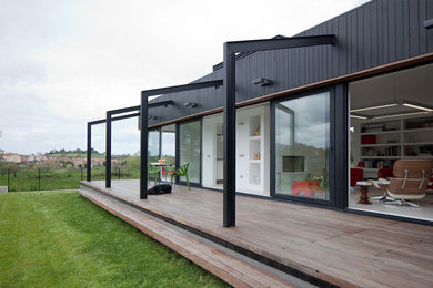 Diseño de fachada negra moderna de una planta con revestimiento de metal y tejado a dos aguas