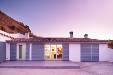 Foto de fachada de casa blanca contemporánea de tamaño medio de una planta con revestimiento de hormigón, tejado de un solo tendido y tejado de teja de barro
