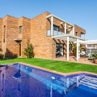 Foto de fachada de casa mediterránea, de dos plantas, con revestimiento de ladrillo y tejado plano