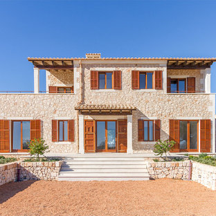 Ejemplo de fachada de casa mediterránea, de dos plantas, con revestimiento de piedra y tejado de teja de barro