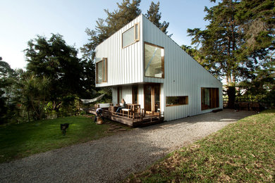 Ejemplo de fachada de casa blanca actual de tamaño medio de dos plantas con revestimiento de metal y tejado de un solo tendido