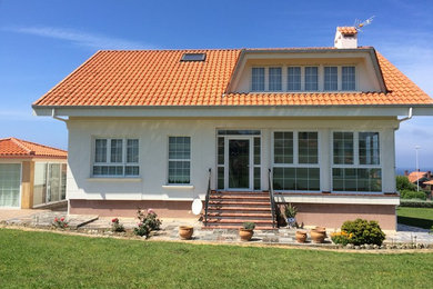 Imagen de fachada blanca tradicional renovada de tamaño medio de dos plantas con revestimientos combinados y tejado a dos aguas