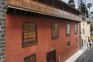 Diseño de fachada roja clásica de tamaño medio de tres plantas con revestimientos combinados y tejado a cuatro aguas