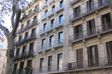Ejemplo de fachada beige clásica renovada de tamaño medio de tres plantas con revestimiento de estuco y tejado plano