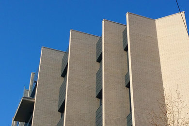 Ejemplo de fachada beige moderna de tamaño medio con revestimiento de ladrillo y tejado plano
