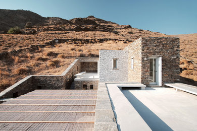 Foto de fachada marrón mediterránea pequeña de dos plantas con revestimiento de piedra y tejado plano