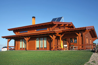 Inspiration pour une façade de maison marron chalet en bois de taille moyenne et à un étage avec un toit de Gambrel et un toit en tuile.