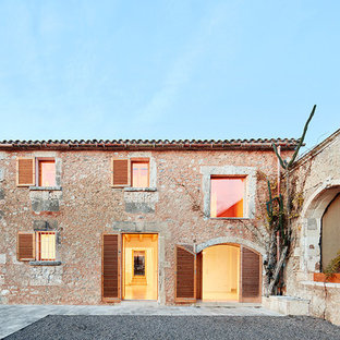 Foto de fachada de casa beige, mediterránea, de dos plantas, con revestimiento de piedra, tejado a dos aguas y tejado de teja de barro