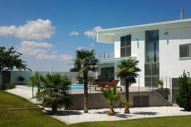 Imagen de fachada blanca mediterránea de tamaño medio de dos plantas con revestimientos combinados