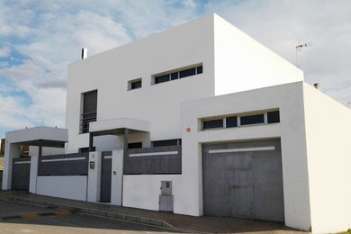 Ejemplo de fachada blanca contemporánea de tamaño medio de tres plantas con revestimiento de aglomerado de cemento y tejado plano