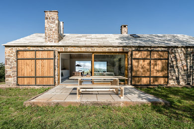 Diseño de fachada de casa beige de estilo de casa de campo de tamaño medio de una planta con revestimiento de piedra y tejado a dos aguas