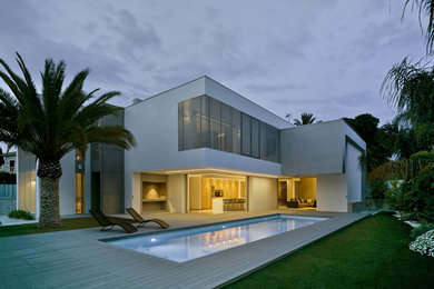 Exemple d'une grande façade de maison blanche tendance à un étage avec un revêtement mixte et un toit plat.