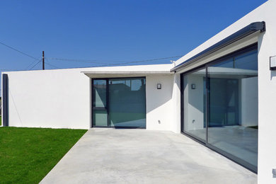Foto de fachada de casa contemporánea pequeña de una planta con revestimientos combinados, tejado plano y tejado de varios materiales