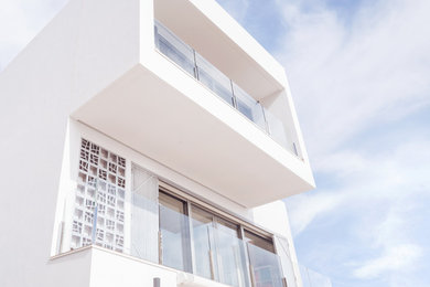 Foto de fachada de casa blanca contemporánea de tamaño medio de tres plantas con revestimiento de estuco y tejado plano