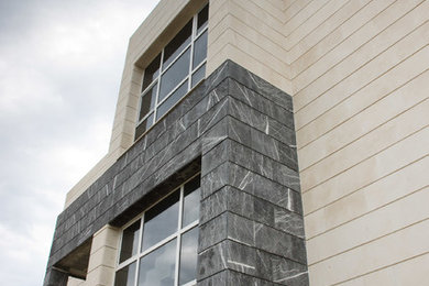 Imagen de fachada contemporánea de tamaño medio de tres plantas con tejado plano y revestimiento de piedra