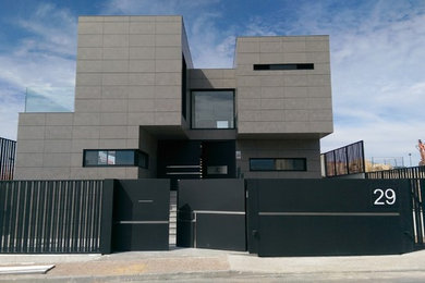 Imagen de fachada beige actual de tamaño medio de tres plantas con revestimientos combinados y tejado plano