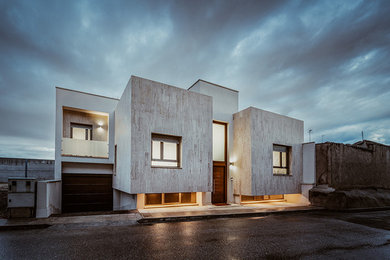 Imagen de fachada de casa beige minimalista de dos plantas con revestimiento de piedra, tejado plano y tejado de varios materiales