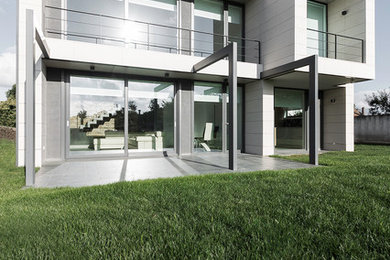 Foto de fachada blanca moderna grande de dos plantas con revestimientos combinados y tejado plano