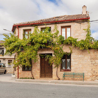 Foto de fachada de casa beige, mediterránea, de dos plantas, con revestimiento de piedra, tejado a cuatro aguas y tejado de teja de barro