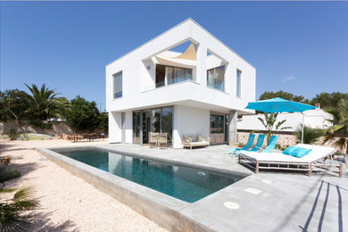 Идея дизайна: двухэтажный, белый частный загородный дом среднего размера в морском стиле с облицовкой из цементной штукатурки, плоской крышей и крышей из смешанных материалов