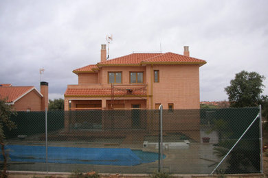Ejemplo de fachada de casa roja y roja moderna grande de dos plantas con revestimiento de ladrillo, tejado a cuatro aguas y tejado de teja de barro
