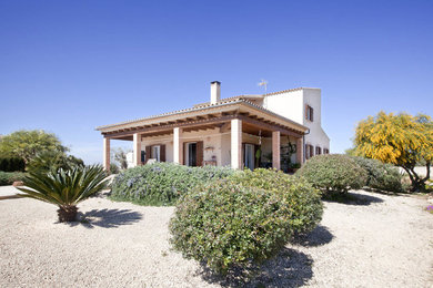 Foto de fachada blanca mediterránea de tamaño medio de dos plantas con revestimiento de estuco y tejado a dos aguas