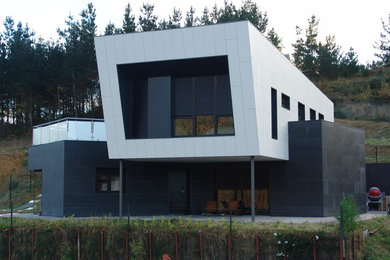 Ejemplo de fachada blanca contemporánea grande de dos plantas con revestimientos combinados y tejado plano