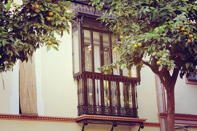 Foto de fachada beige clásica renovada de tres plantas con tejado plano