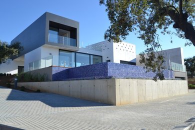 Imagen de fachada blanca contemporánea de tamaño medio de tres plantas con revestimientos combinados y tejado plano
