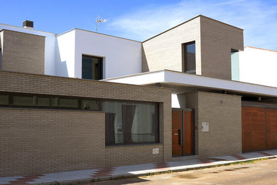 Ejemplo de fachada gris actual de tamaño medio de dos plantas con revestimientos combinados y tejado plano