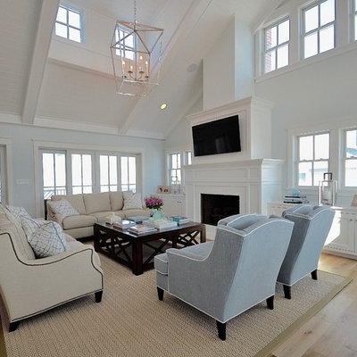 Beach style light wood floor family room photo in Philadelphia with blue walls, a standard fireplace and a wall-mounted tv