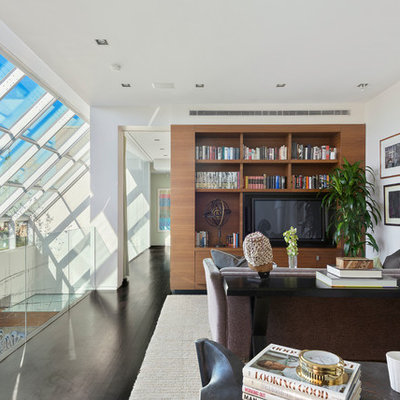 Inspiration for a large contemporary dark wood floor family room library remodel in New York with white walls, no fireplace and a media wall