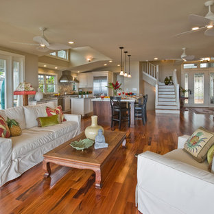 Family room - tropical open concept medium tone wood floor and brown floor family room idea in Hawaii with beige walls