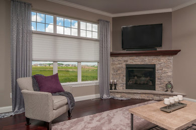 Example of a mid-sized transitional open concept vinyl floor family room design in Other with brown walls, a standard fireplace, a stone fireplace and a wall-mounted tv