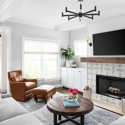 Example of a farmhouse open concept medium tone wood floor and brown floor family room design in Chicago with gray walls, a standard fireplace, a tile fireplace and a wall-mounted tv