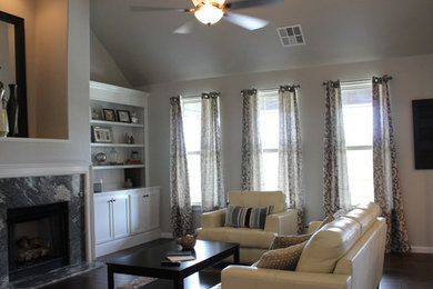 Inspiration for a mid-sized transitional open concept medium tone wood floor family room library remodel in Oklahoma City with gray walls, a standard fireplace and a stone fireplace